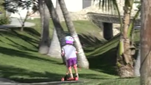 SAN JOSE DEL CABO MEXICO-2019: Child Wearing Purple Shorts Rides Orange Scooter