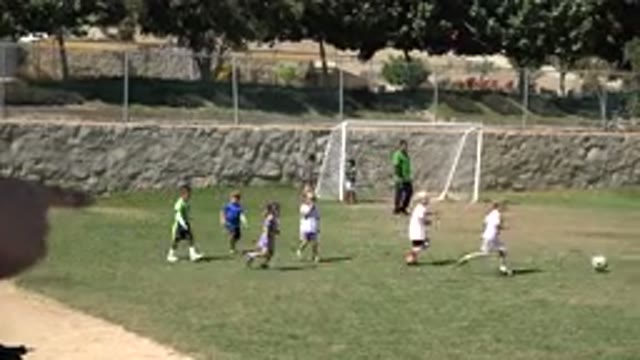 SAN JOSE DEL CABO MEXICO-2019: Man Wearing Green Shirt Watches Kids Playing Soccer