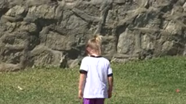SAN JOSE DEL CABO MEXICO-2019: A Boy in a White Shirt and Purple Shorts Running on Grass