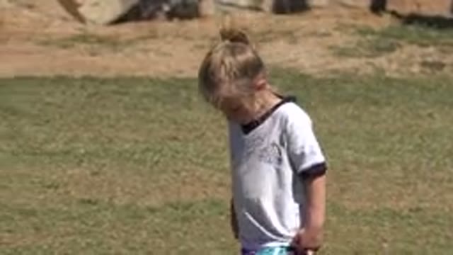 SAN JOSE DEL CABO MEXICO-2019: A Little Blond Girl Walks In The Park While She Fixes Her Hair