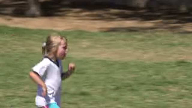 SAN JOSE DEL CABO MEXICO-2019: Girl Wearing White Shirt Runs On Green Grass On A