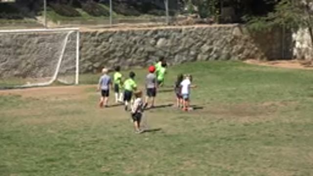 SAN JOSE DEL CABO MEXICO-2019: A Group Of Kids Practice Soccer On A Grassy Field