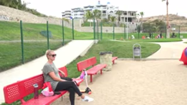 SAN JOSE DEL CABO MEXICO-2019: A White Woman Sits On A Bench At A Park