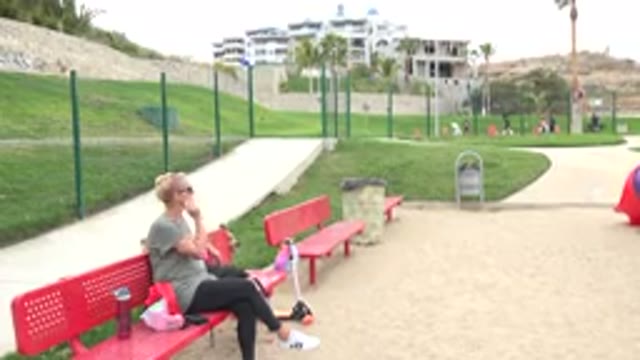 SAN JOSE DEL CABO MEXICO-2019: Woman Sitting On A Red Bench Looking Back At Her