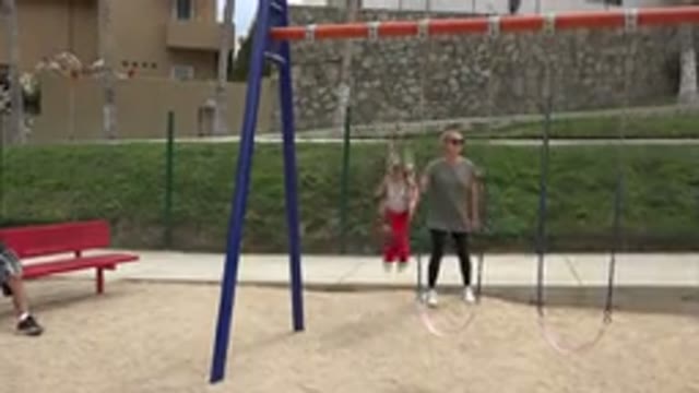 SAN JOSE DEL CABO MEXICO-2019: Woman In Sunglasses Pushing Little Girl On A Swing