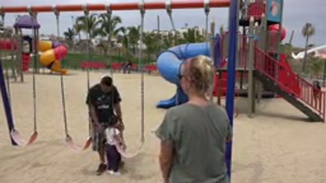SAN JOSE DEL CABO MEXICO-2019: Adults Push Children On Swings At Public Playground