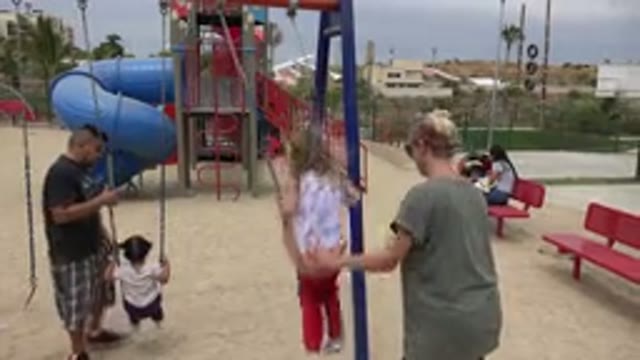 SAN JOSE DEL CABO MEXICO-2019: Woman Wearing Grey Shirt Pushes Girl Wearing Red