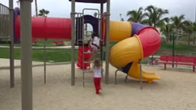 SAN JOSE DEL CABO MEXICO-2019: Girl Wearing Red Pants Climbs Ladder To Yellow