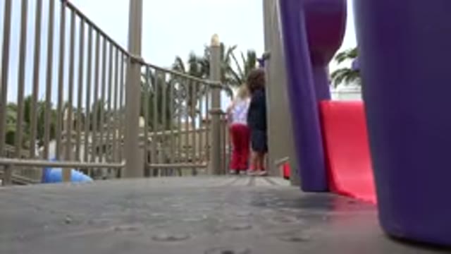 SAN JOSE DEL CABO MEXICO-2019: Girl Wearing Red Pants Jumps Down Grey Step Outdoors