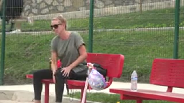 SAN JOSE DEL CABO MEXICO-2019: Woman Sitting on Red Bench with Water Bottle in Park