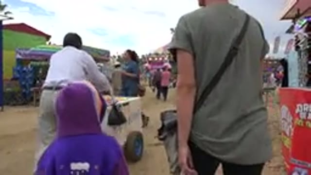 SAN JOSE DEL CABO MEXICO-2019: A Woman And A Child Walk Through An Amusement Park