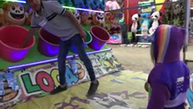 SAN JOSE DEL CABO MEXICO-2019: A Young Girl Wearing A Rainbow Sweater Playing A Carnival Game