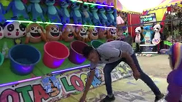 SAN JOSE DEL CABO MEXICO-2019: Little Girl Attempts To Throw Ball Into Bucket To Win Prize