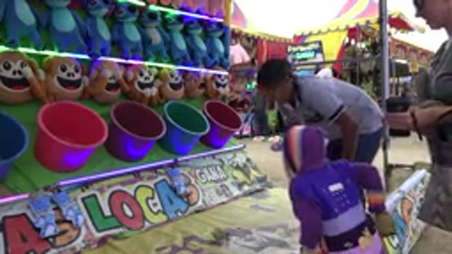 SAN JOSE DEL CABO MEXICO-2019: Child Wearing Purple Jacket Tosses Yellow Ball