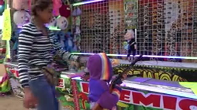 SAN JOSE DEL CABO MEXICO-2019: Carnival Worker Helps Child With Game