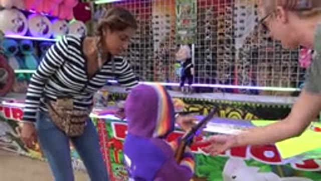 SAN JOSE DEL CABO MEXICO-2019: Woman Wearing Grey Shirt Helps Child Wearing Purple Jacket