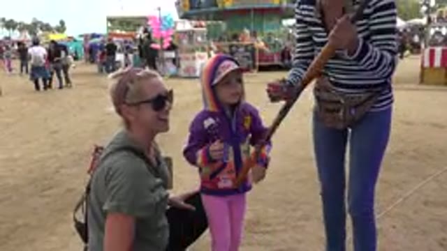 SAN JOSE DEL CABO MEXICO-2019: Two Adults Teaching Child How To Prepare And Handle Toy Rifle