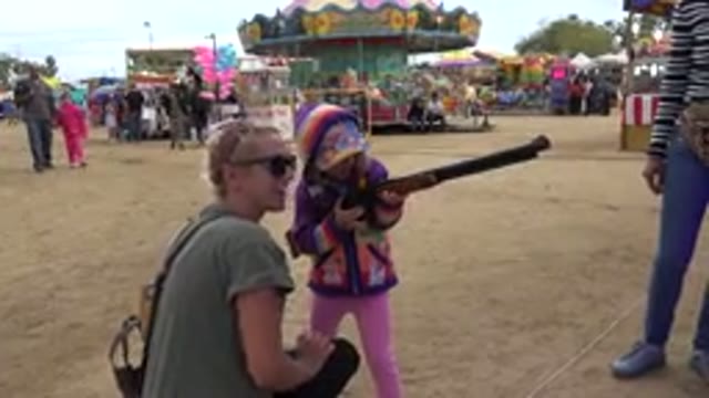 SAN JOSE DEL CABO MEXICO-2019: A Girl in Bright Pink Clothes Aims With a Rifle