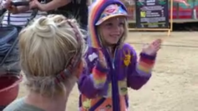 SAN JOSE DEL CABO MEXICO-2019: Girl in Hat and Coat Claps with Mother at Carnival Game