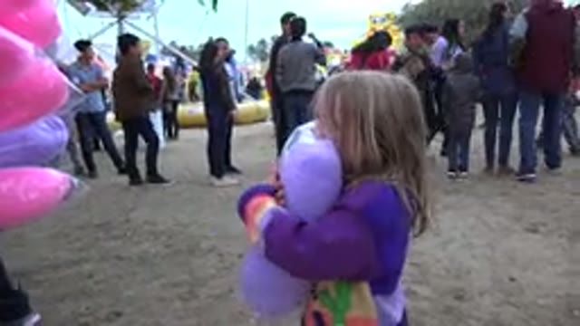 SAN JOSE DEL CABO MEXICO-2019: Little Girl Hugging Her Mother with Purple Cotton Candy