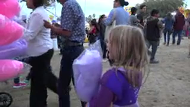 SAN JOSE DEL CABO MEXICO-2019: Little Girl Holding Cotton Candy Observing The Carnival
