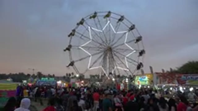 SAN JOSE DEL CABO MEXICO-2019: Enormous Neon Ferris Wheel Glowing Over A Jovial Crowd