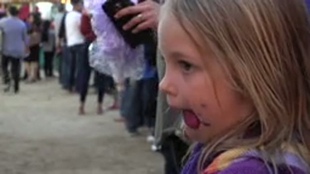 SAN JOSE DEL CABO MEXICO-2019: A Little Girl Standing in a Crowd Licking Her Cotton Candy
