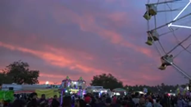 SAN JOSE DEL CABO MEXICO-2019: Pink Clouds In Pale Blue Sky Ferris Wheel Spins