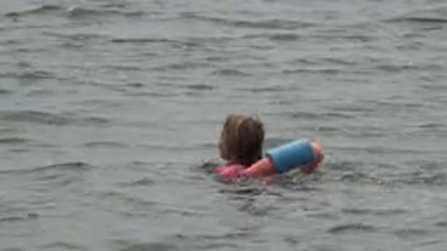 SAN JOSE DEL CABO MEXICO-2019: Girl Swimming Using Swim Ring While Being Encouraged