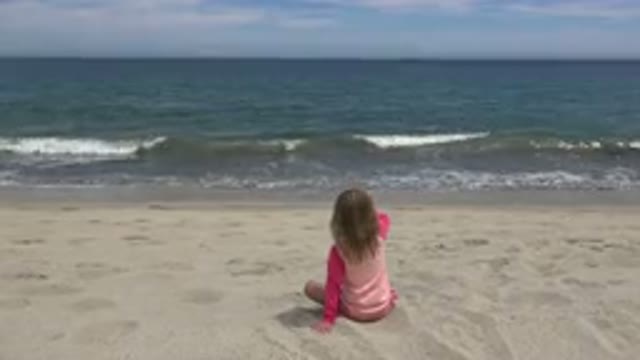SAN JOSE DEL CABO MEXICO-2019: A Child Sits on the Sand Watching Waves