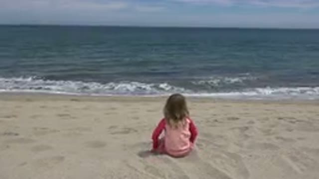 SAN JOSE DEL CABO MEXICO-2019: Blonde Child Wearing Pink Crawling On The Sand In