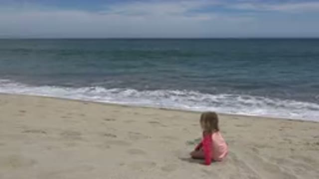 SAN JOSE DEL CABO MEXICO-2019: A Little Girl Sitting On The Beach Getting Up And Walking