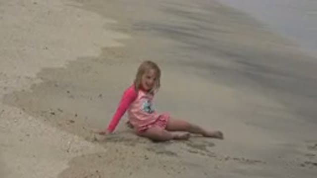 SAN JOSE DEL CABO MEXICO-2019: Girl Wearing Pink Shirt Sits On Tan Beach Sand On