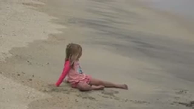 SAN JOSE DEL CABO MEXICO-2019: A Young Girl Sits On A Beach While The Surf Washes