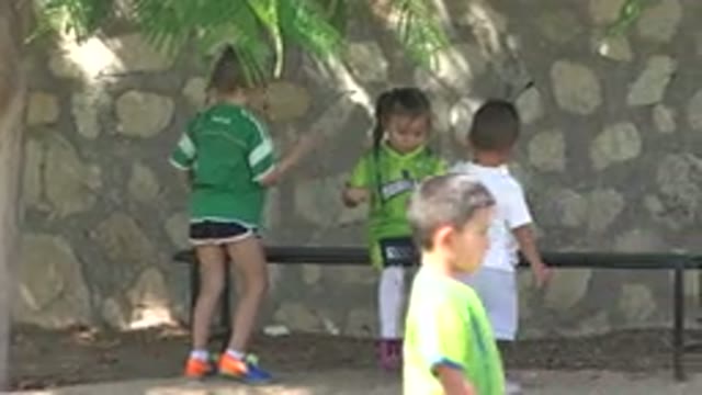 SAN JOSE DEL CABO MEXICO-2019: Girl Wearing Green Shirt Sits On Black Bench