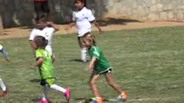 SAN JOSE DEL CABO MEXICO-2019: Two Kids Running in a Field Wearing Green Shirts
