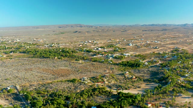 TODOS SANTOS BCS MEXICO-2021: Car Moving Along Desert Road with Sparse Vegetation