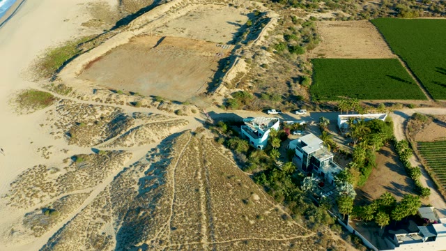 TODOS SANTOS BCS MEXICO-2021: Car Moving on Coastal Road by Sandy Beach and Farmland