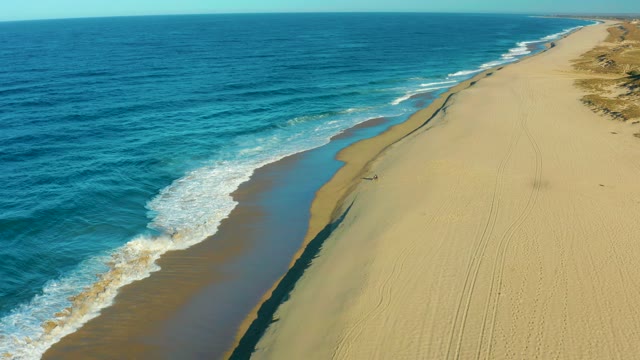 TODOS SANTOS BCS MEXICO-2021: Waves Rolling Onto Sandy Shore with Person Walking