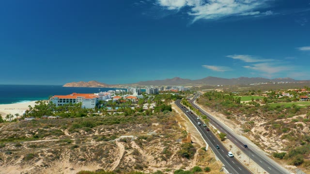 MARQUIS LOS CABOS MEXICO-2021: Coastal Highway Traffic and Beachfront Buildings