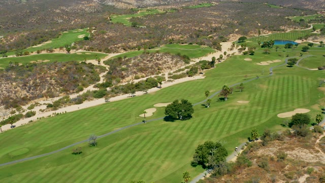 MARQUIS LOS CABOS MEXICO-2021: Golfer and Cart Moving Across Golf Course