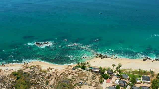 MARQUIS LOS CABOS MEXICO-2021: Coastal Waves Hitting Rocky Shore with Boat Passing by