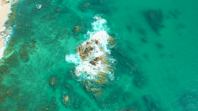 MARQUIS LOS CABOS MEXICO-2021: Waves Crashing on Rocky Seabed Near Sandy Shore