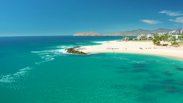 MARQUIS LOS CABOS MEXICO-2021: Beachgoers Moving Along Sandy Shoreline