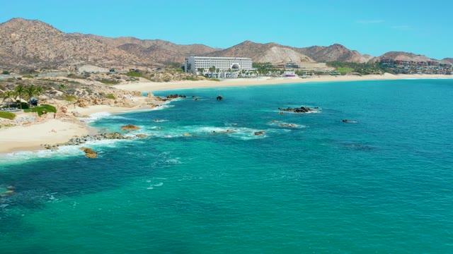 MARQUIS LOS CABOS MEXICO-2021: Waves Crashing on Rocky Shoreline with Sandy Beach