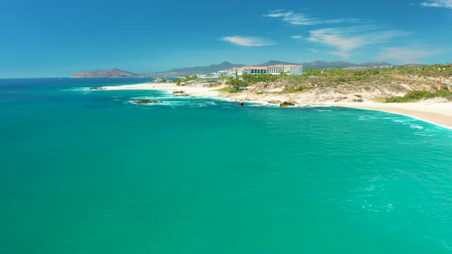 MARQUIS LOS CABOS MEXICO-2021: Waves Breaking on Sandy Coast with Coastal Building