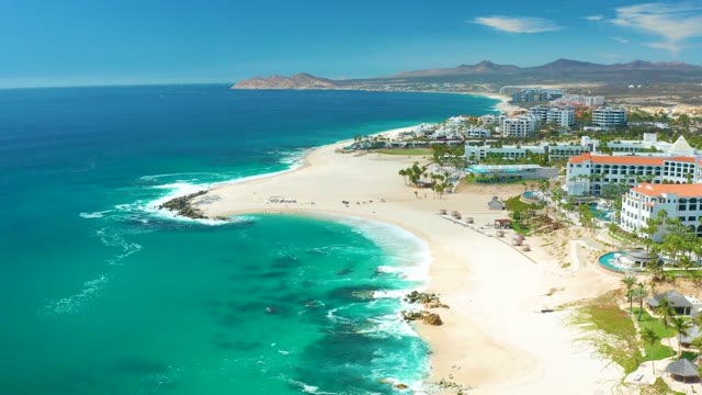 MARQUIS LOS CABOS MEXICO-2021: Waves Crashing on Sandy Shore with Resort Buildings