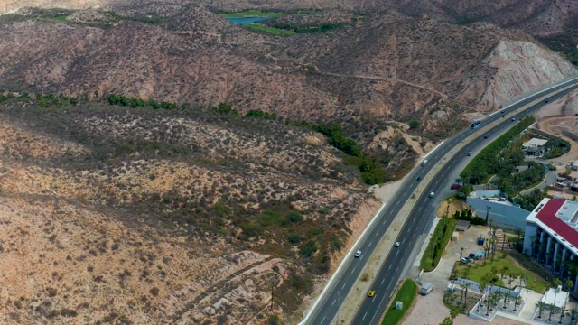 MARQUIS LOS CABOS MEXICO-2021: Highway Through Arid Hills with Moving Traffic