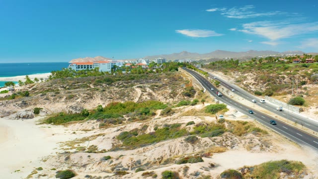 MARQUIS LOS CABOS MEXICO-2021: Coastal Highway with Moving Vehicles and Sandy Shore