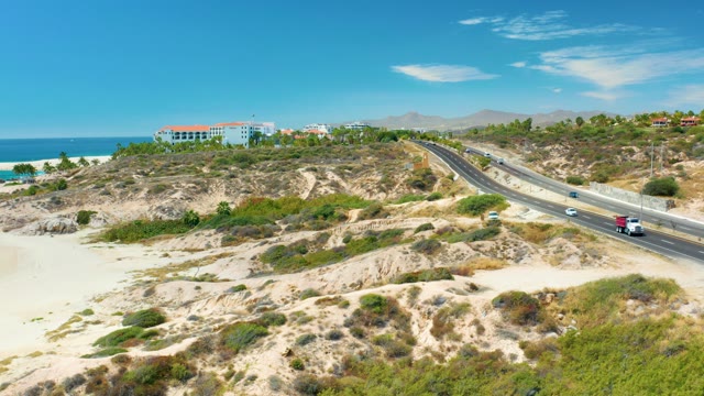 MARQUIS LOS CABOS MEXICO-2021: Coastal Highway Traffic Along Sandy Hills and Beach